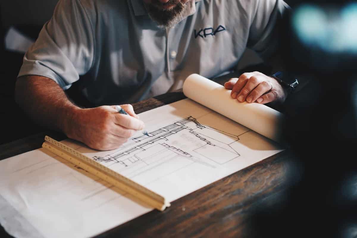Technical plan drawings and drafting instruments laid out on a site office table